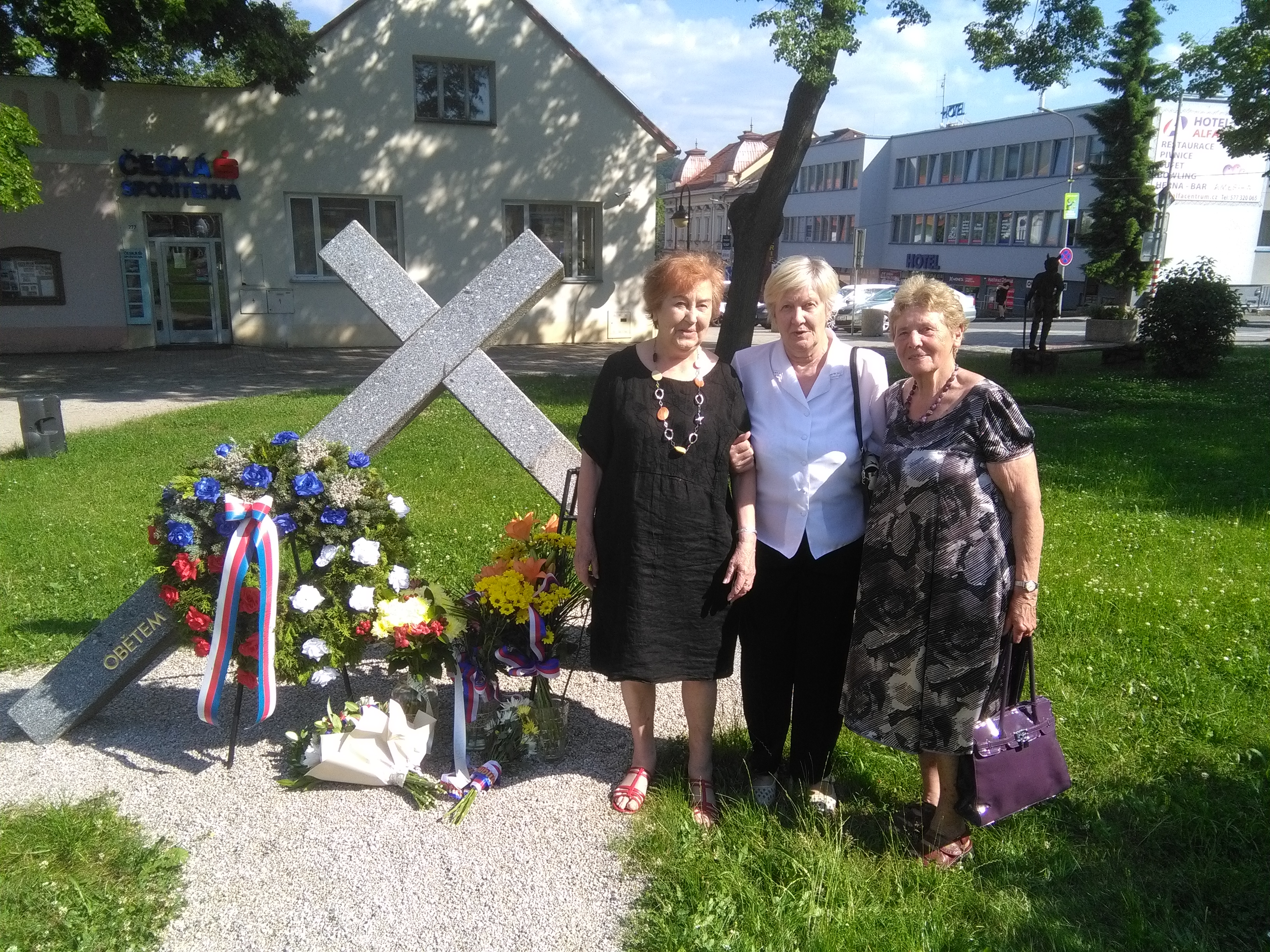 Jana Vozárová, Marie Janalíková a Eva Langrová stojící před památníkem
